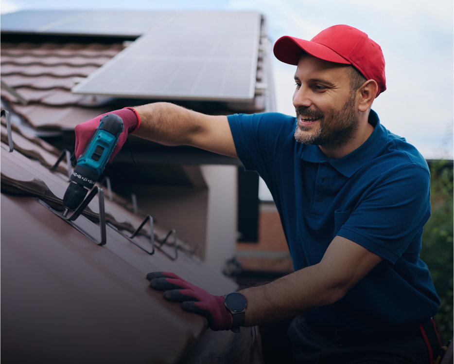 Man installing solar panels on rooftop.