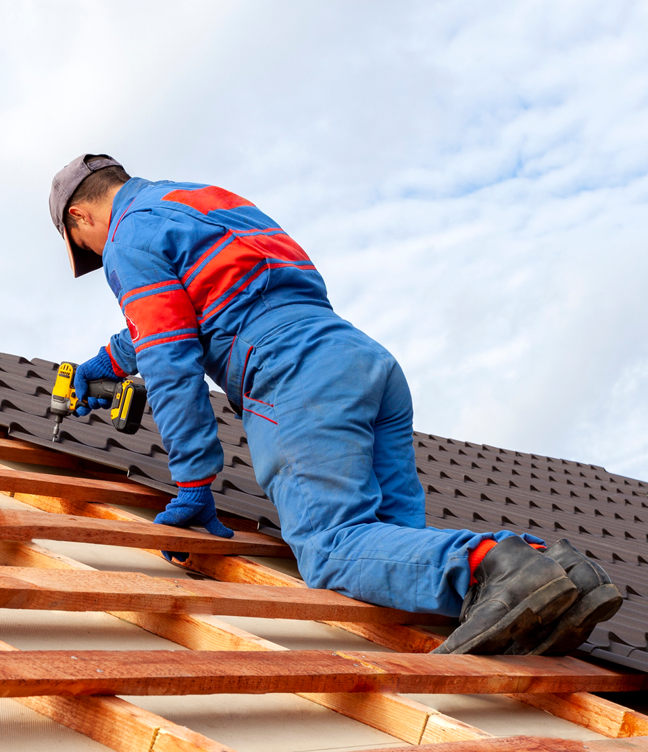 Roofer installing shingles on a roof.