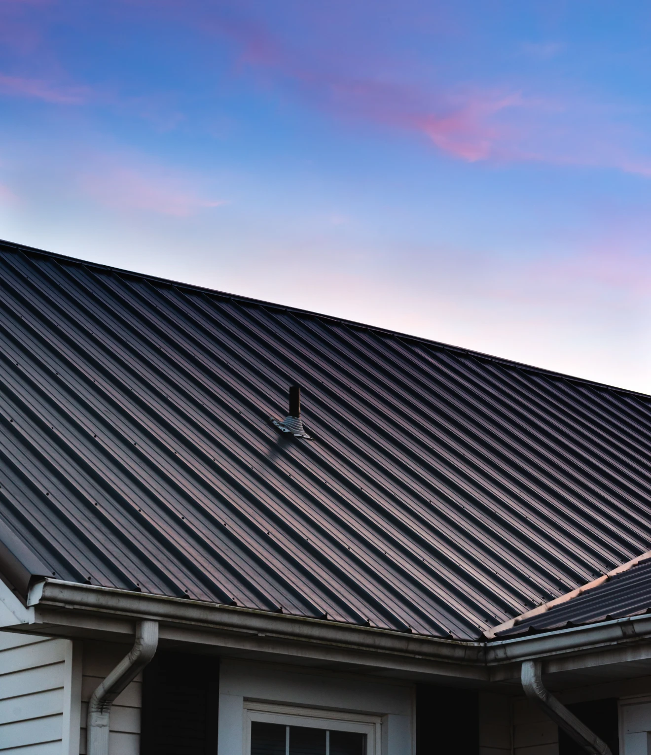 Metal roof against a colorful evening sky.