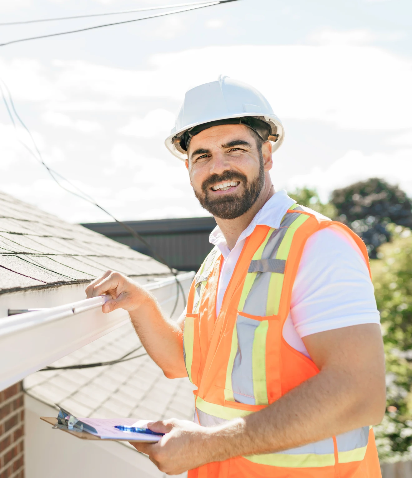 Construction worker inspecting a roof gutter.